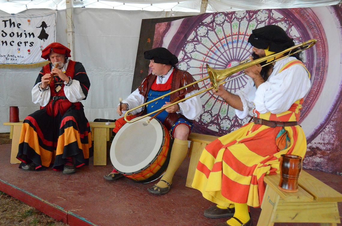 Renaissance faire musicians in period costume performing for guests