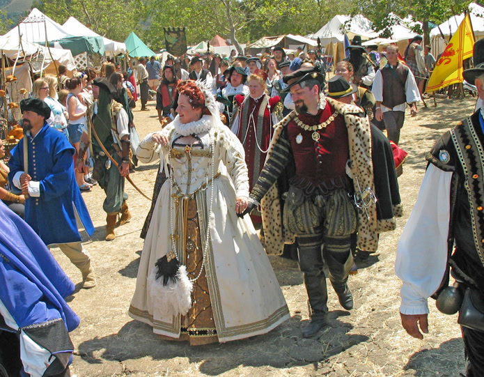 Royal couple in elaborate Renaissance faire costumes with period details